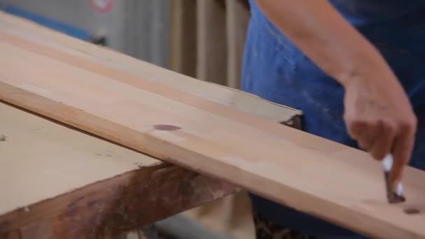 Рабочий шлифует деревянную деталь на мебельной фабрике. Шлифовка деревянной мебели. Процесс производства мебели — стоковое видео