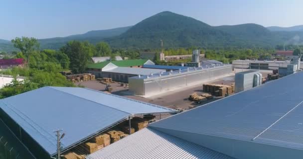 Μεγάλο εργοστάσιο επίπλων με φόντο τα βουνά, εναέρια άποψη. Ένα σύγχρονο εργοστάσιο επίπλων σε ένα γραφικό περιβάλλον. Ένα φυτό σε μια όμορφη ορεινή περιοχή — Αρχείο Βίντεο