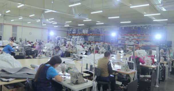 Molte sarte lavorano in una fabbrica di abbigliamento. Processo di lavorazione in una fabbrica di abbigliamento. Grande laboratorio di cucito. Le sarte producono prodotti in una fabbrica. Fabbrica di abbigliamento — Video Stock