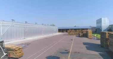 Forklift taşıma kerestesi fabrikadan geçiyor. Bir marangoz fabrikasının üzerinde bir uçuş. Modern mobilya fabrikasının genel planı.