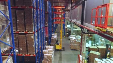 Depodaki modern ekipmanların işi. Kutularla dolu bir depoda modern forklift.