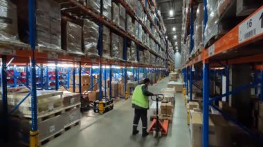 İnsanlar depo zaman aralığında çalışıyor. Modern bir depoyla çalışıyorum. İşçiler karton kutuları bir depoda taşıyorlar.