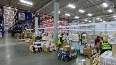 İnsanlar büyük bir depoda çalışıyor. Modern bir depoda zaman ayarlı. İnsanlar depo zaman aralığında çalışıyor. Modern bir depoda çalışıyorum.