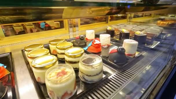 Süße Desserts auf der Theke in einem Café. Viele leckere Desserts im Ladenregal. — Stockvideo