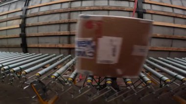 Kamyon römorku boşaltılırken konveyörde karton gezintisi. Malzemeler stokta