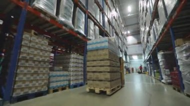 Modern bir forklift depodan geçiyor. Büyük, modern bir depo. Kargo modern bir forkliftle depodan taşınıyor.