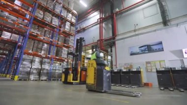 Depo işi. Modern yükleyiciler büyük bir depoda. Büyük bir depoda iş akışı. Fabrikanın deposunda özel ekipman var..