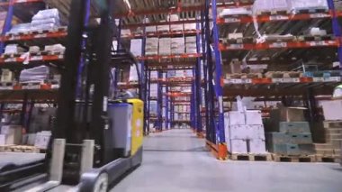 Fabrikanın deposunda özel ekipman var. Depoyu turlayan bir sürü forklift var. Modern yükleyiciler büyük bir depoda.