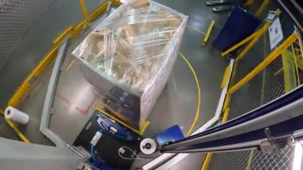 Verpackung von Schachteln in Plastikfolie. Box Stretch Verpackungsmaschine. Palettenwickelmaschine. Maschine zum Einwickeln von Schachteln in Plastikfolie im Kreis. — Stockvideo