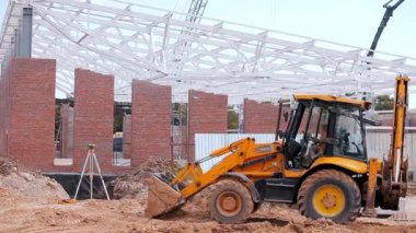 İnşaat alanında sarı traktör. Profesyonel inşaat malzemeleri. İnşaat alanında çalışma süreci