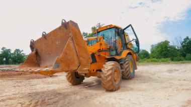 İnşaat alanında sarı traktör. İnşaat alanında çalışma süreci. Profesyonel inşaat ekipmanları.