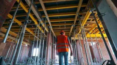 İnşaatçı inşaat halindeki binanın içine giriyor. Evin içinde inşaatçı var. İnşaatçı inşaat alanına gider..