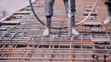 Güçlendirilmiş beton yapı oluştururken çimento dökülüyor. Formalitenin içine çimento dökülüyor. Biçim oluşturma