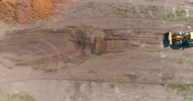 İnşaat alanında büyük sarı bir traktör. İnşaat alanında çalışma süreci. İnşaat alanında profesyonel ekipman.