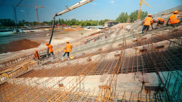 Working process at a construction site. Workers make a reinforced concrete structure. Reinforced concrete. Pouring concrete to a metal structure. — Stockvideo