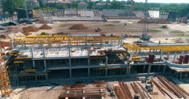 Proces budowy nowoczesnego stadionu piłkarskiego. Budowniczowie wykonują szalunki na budowie nowego stadionu. Widok z lotu ptaka na konstrukcję żelbetową — Wideo stockowe