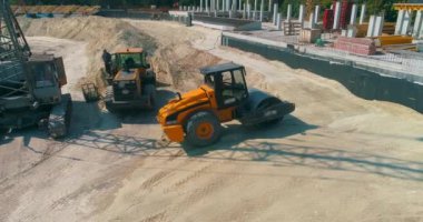 Toprak sıkıştırıcı, Dünya 'yı bir inşaat alanında hizaladı. Toprak sıkıştırıcı bir inşaat alanında zemini sıkıştırıyor.