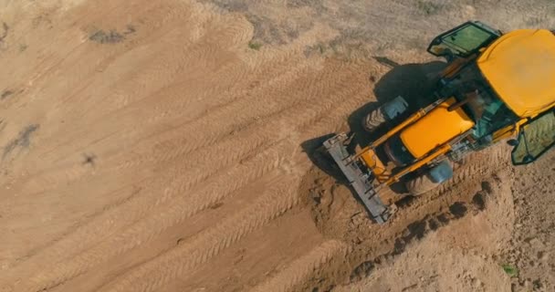 Grand tracteur jaune sur un chantier. Processus de travail sur un chantier de construction. Equipement professionnel sur le chantier — Video