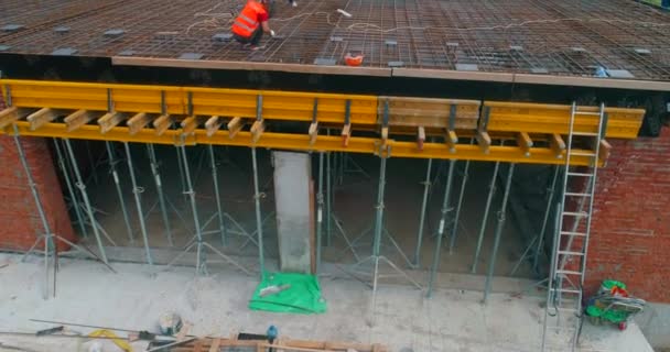 Bauarbeiter stellen Schalungen auf der Baustelle für ein neues Stadion her. Bau eines modernen Fußballstadions. Luftaufnahme der Stahlbetonkonstruktion — Stockvideo