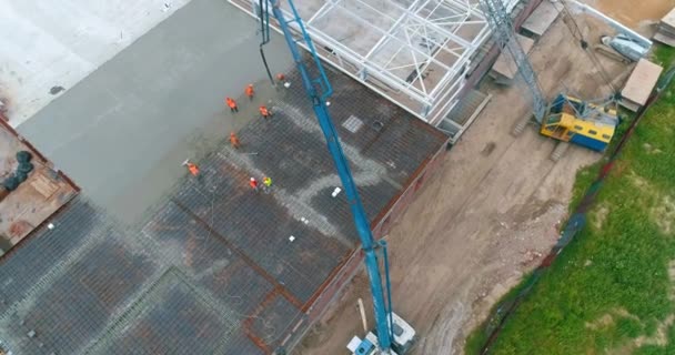 Processen att skapa ett betonggolv. Häll formen med betong. Utsikt från drönaren. Byggnadsarbeten på en byggarbetsplats — Stockvideo