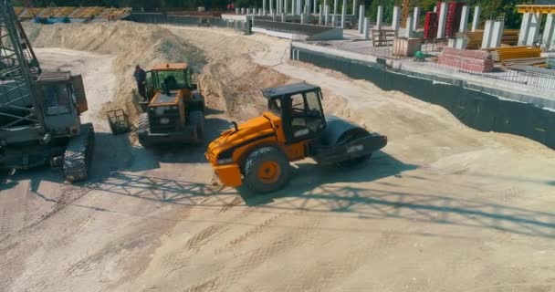 Compactador de solo alinha a terra em um canteiro de obras. Compactador de solo compacta o solo em um canteiro de obras — Vídeo de Stock