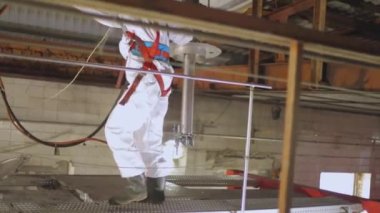 Tankerin otomatik buhar temizliği. Kimyasal koruma işçisi. Bir işçi içeriden buharlı bir tank kamyonunun kimyasal temizliğini yapar..