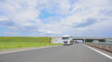 Otoyol boyunca giden beyaz bir kamyon. Tankerli bir kamyon güneşli havada otoyola çıkıyor. Bir kamyon konvoyu otoban boyunca gidiyor.