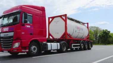 Bir grup kamyon otoyol boyunca gidiyor. Tank kamyonu olan bir kamyon otoyolda gidiyor. Modern kamyonlar sıvı kargoyu tanklarla taşır. Kırmızı kamyon otoyol boyunca gidiyor..