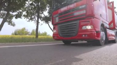 Kırmızı kamyon otoyol boyunca gidiyor. Bir grup kamyon otoyol boyunca gidiyor. Modern kamyonlar tanklarda sıvı kargo taşıyorlar