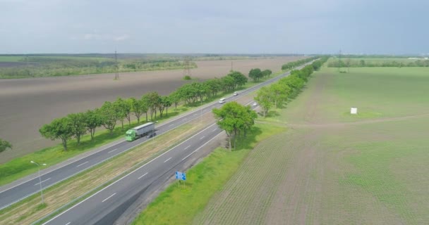 Die Straße reicht von der Drohne bis zum Horizont. Mit Autos und Lastwagen über eine Autobahn geflogen. Fliegen über eine moderne Autobahn. — Stockvideo