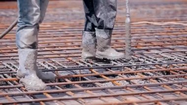 Güçlendirilmiş beton yapı oluştururken çimento dökülüyor. Formalitenin içine çimento dökülüyor. Biçim oluşturma