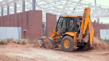 Traktör inşaat alanında çalışıyor. İnşaat alanında çalışma süreci. Traktör kovası yaklaş.