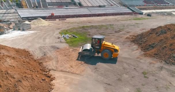 Bodenverdichter richtet Erde auf einer Baustelle aus. Bodenverdichter verdichtet den Boden auf einer Baustelle — Stockvideo