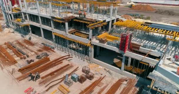 Los constructores hacen encofrados en el sitio de construcción de un nuevo estadio. Proceso de construcción de un estadio de fútbol moderno. Vista aérea de la construcción de hormigón armado — Vídeo de stock