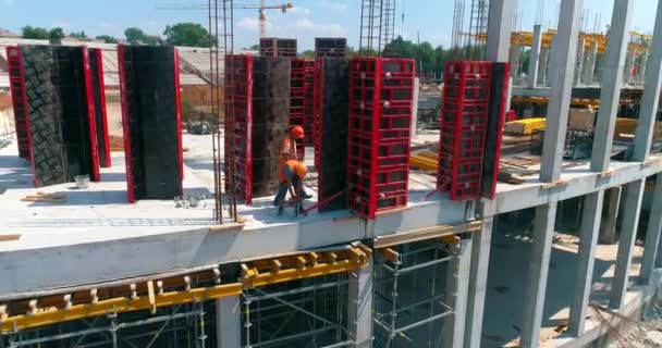 Byggande av en modern fotbollsstadion. Byggare gör formarbete på byggarbetsplatsen för en ny stadion. Flygfoto av armerad betongkonstruktion — Stockvideo
