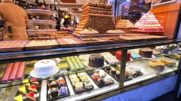 Słodkie desery na ladzie w kawiarni. Wiele pysznych pięknych deserów na półce sklepowej. — Wideo stockowe