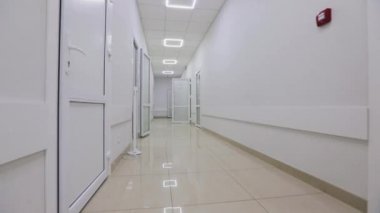 Kamera hastanenin boş koridoru boyunca döner. Modern bir hastanenin koridorları. Kliniğin boş, parlak koridoru. Modern bir kliniğin içinde.