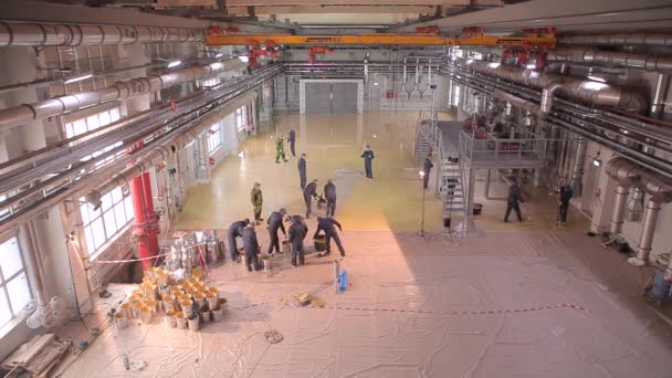 İşçiler fabrikanın atölyesinde zemin hazırlıyorlar. İnşaat alanında çalışanlar. Fabrikada yeni bir atölye inşaatı — Stok video