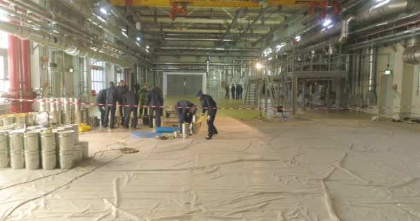 Будівельники роблять самовирівнюючу підлогу на заводі майстерні. Самостійна підлога над великою площею. Наливна підлога в майстерні — стокове відео