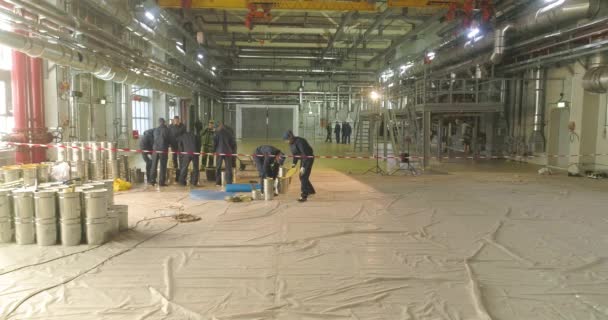 In der Werkshalle legen die Bauarbeiter einen selbstnivellierenden Boden an. Selbstnivellierender Boden über eine große Fläche. Selbstnivellierender Boden in der Werkstatt — Stockvideo