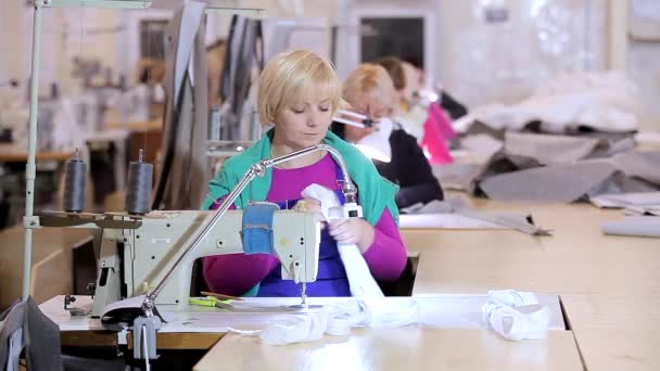 Een naaister werkt in een kledingfabriek. Textielproductie. het werkproces. Naaien van professionele apparatuur — Stockvideo