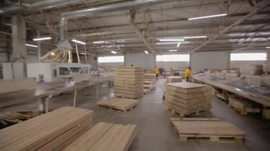 İşlenmiş ahşap parçaları düzgünce katlanmış. Marangozhanenin içinde. Bir marangoz fabrikasında çalışma süreci