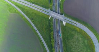 Trafik kavşağı üst görünümü değiştir. Arabalar otoban boyunca gidiyor, manzarası çok güzel. Bir yol kavşağının üzerinden uçuyorlar. Arabalar şehrin dışındaki otoyol boyunca ilerliyorlar.