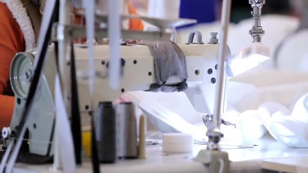 縫製工場でのミシン機器。縫製工場での縫製工程のクローズアップ。織物工場の設備 — ストック動画