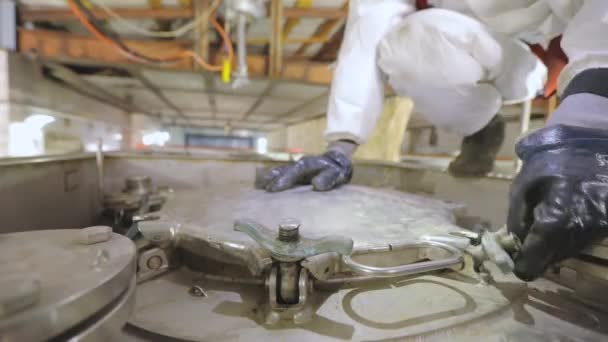 A worker in chemical protection opens a hatch on a truck tank. A worker in a protective suit at a cleaning station. Worker works with hazardous chemicals — Stock Video