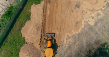 İnşaat alanında büyük sarı bir traktör. İnşaat alanında çalışma süreci. İnşaat alanında profesyonel ekipman.