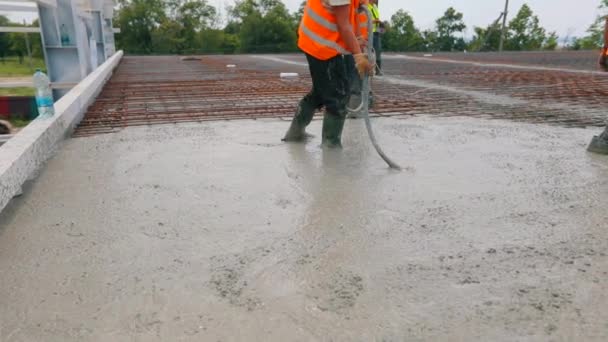 Förstärkt betong. Arbetarna skapar en förstärkt betongstruktur. Hällande betong för metallstomme — Stockvideo