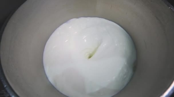 Το γάλα περιστρέφεται σε ένα μεγάλο βαρέλι. Προετοιμασία παγωτού. Γάλα ανάδευσης σε εργοστάσιο. — Αρχείο Βίντεο