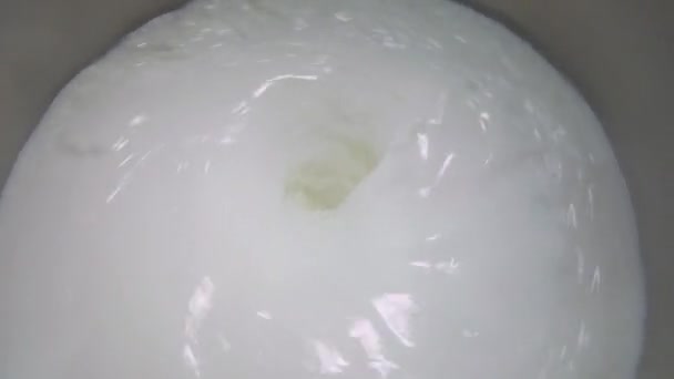 Το γάλα περιστρέφεται σε ένα μεγάλο βαρέλι. Προετοιμασία παγωτού. Γάλα ανάδευσης σε εργοστάσιο. — Αρχείο Βίντεο