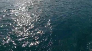 Güneş, suya yansıyor. Dalgalar güneşi yansıtıyor.